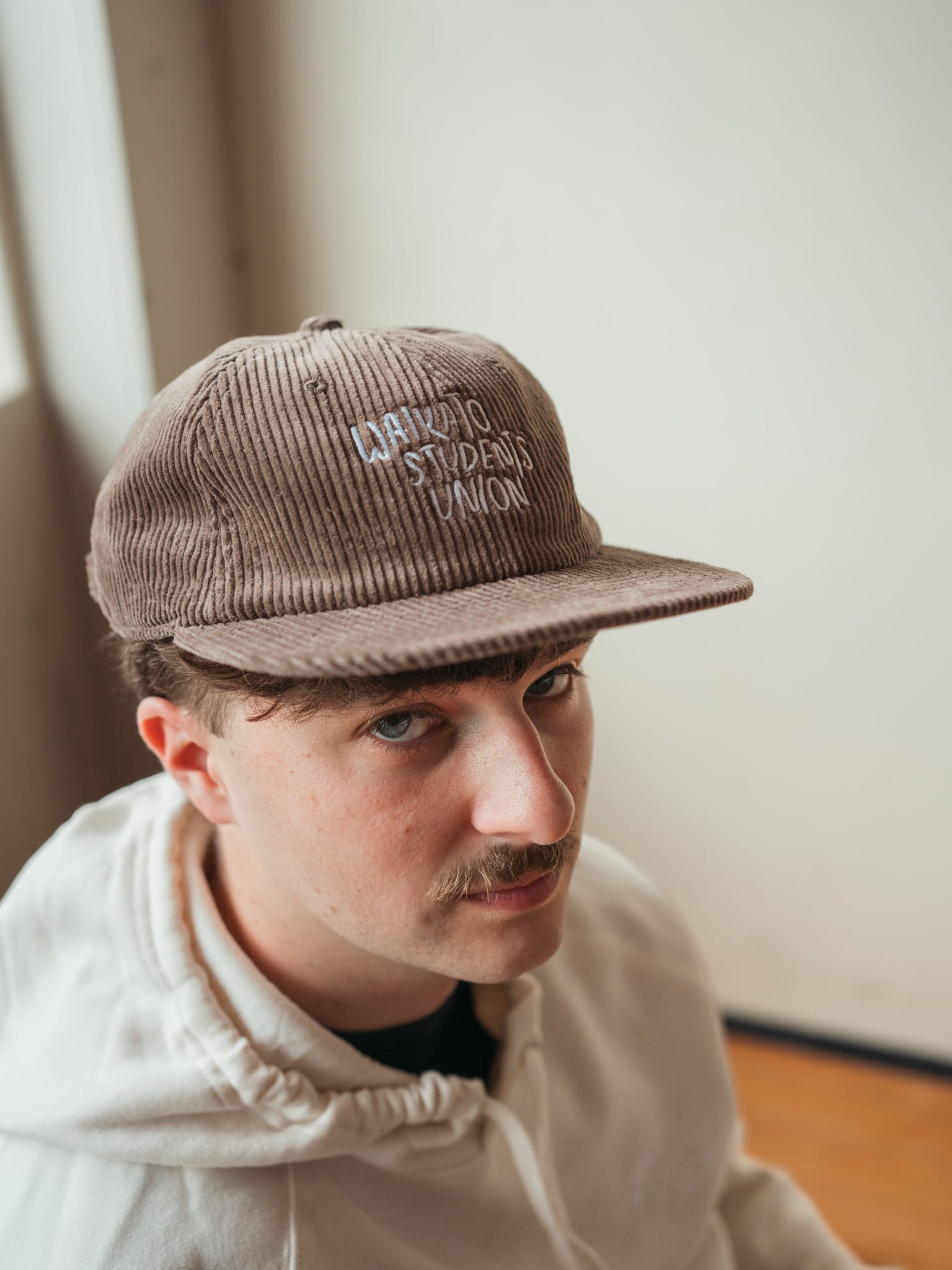 Close crop of Seamus in the corduroy Waikato Students’ Union cap