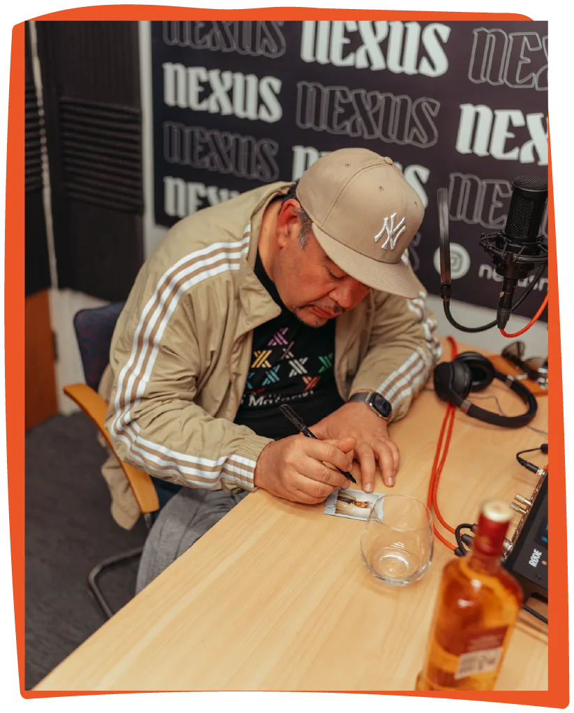 Behind the scenes at the Nexus studio: a guest in a Yankees cap at the desk mid-episode