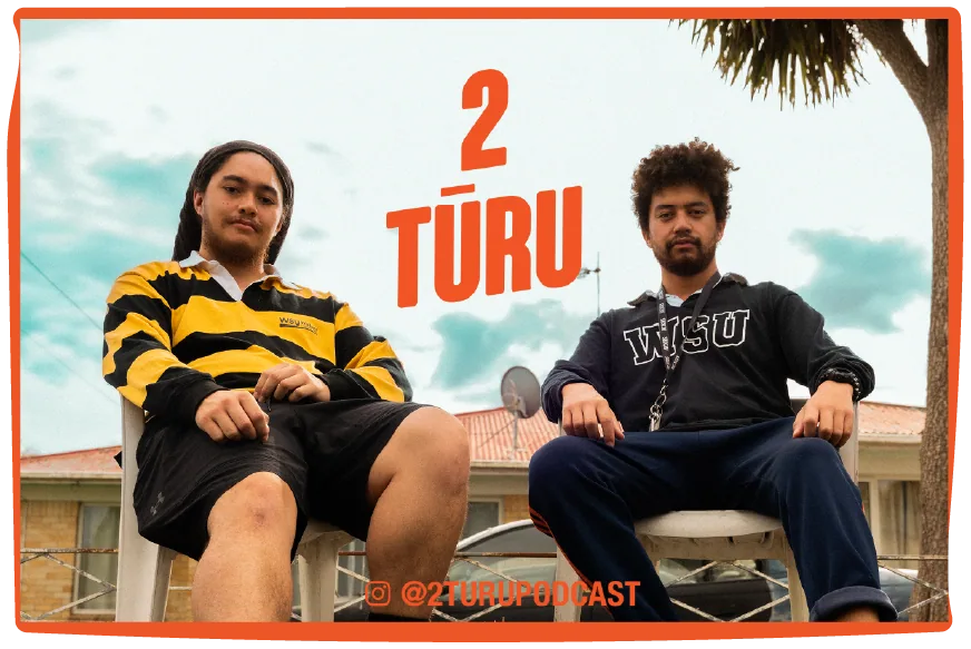 The 2 Tūru billboard shot: Kae’sharn and Harley in their chairs under the logo