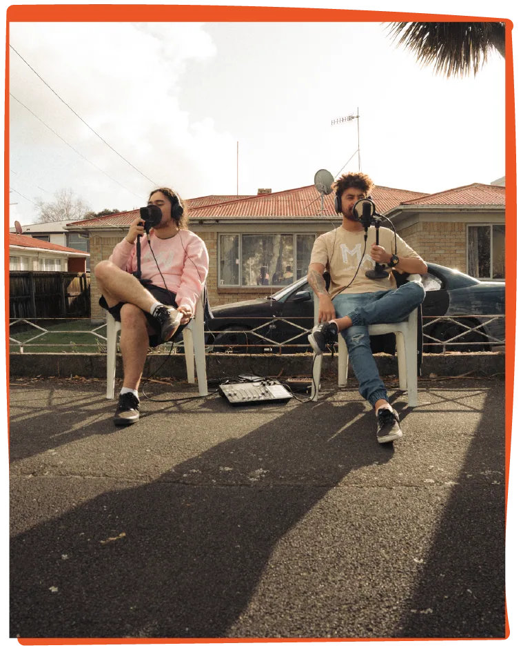 Recording on the street: both hosts filming from their chairs on the road